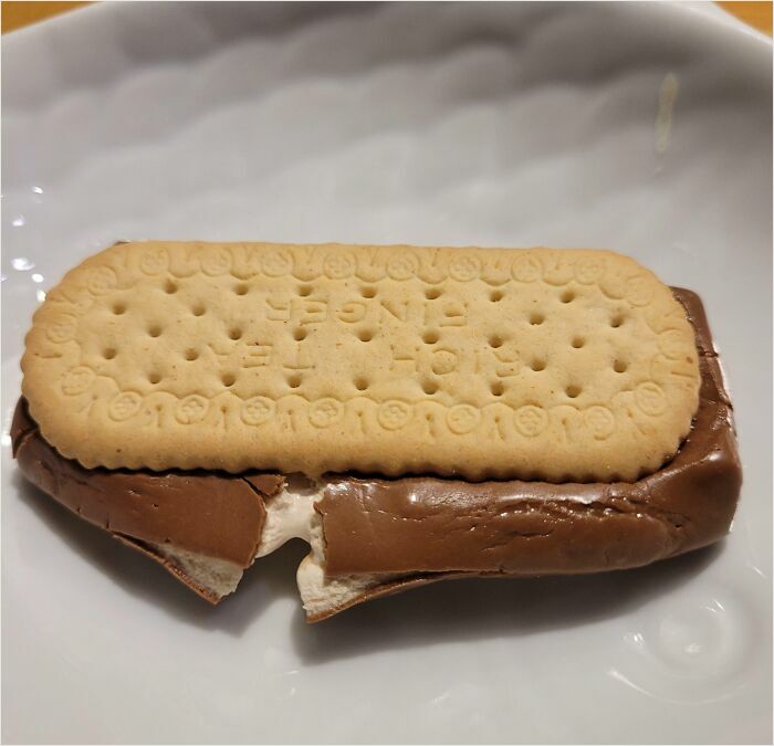 British humor: a biscuit placed on a chocolate bar in a dish, showcasing an unconventional snack.