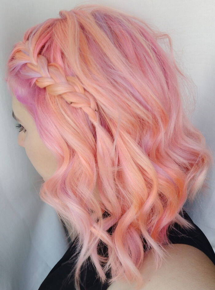 Pastel pink braided hairstyle showcasing changing hair color.