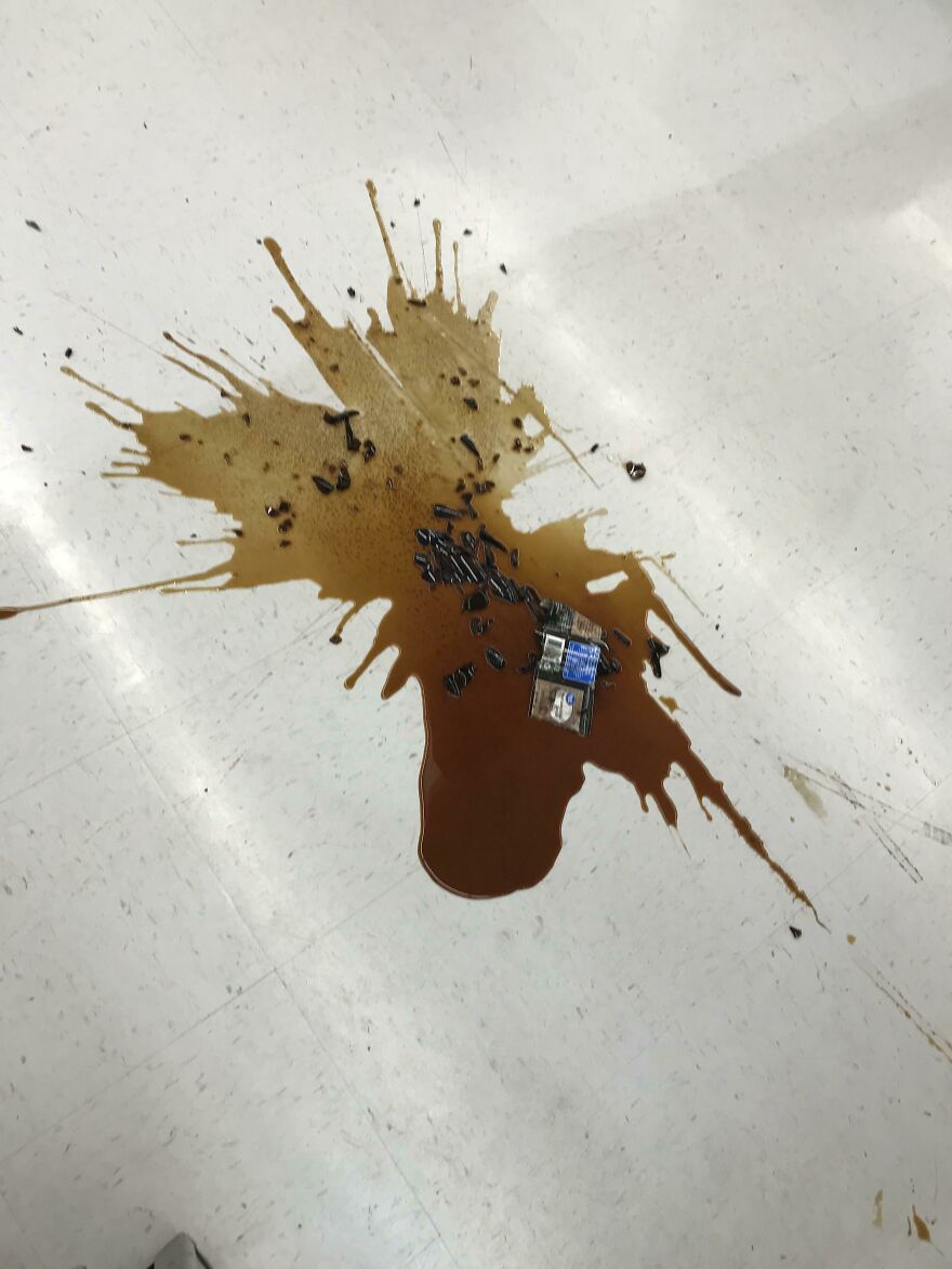 A spilled liquid resembling abstract art on a white floor, showcasing accidental art pics.