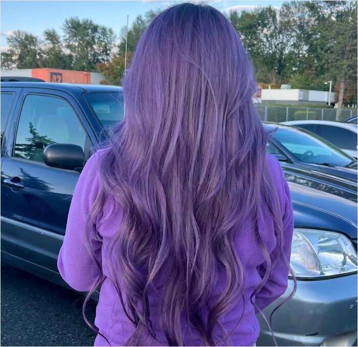 Purple hair transformation in a parking lot setting, showcasing vibrant changing hair color.