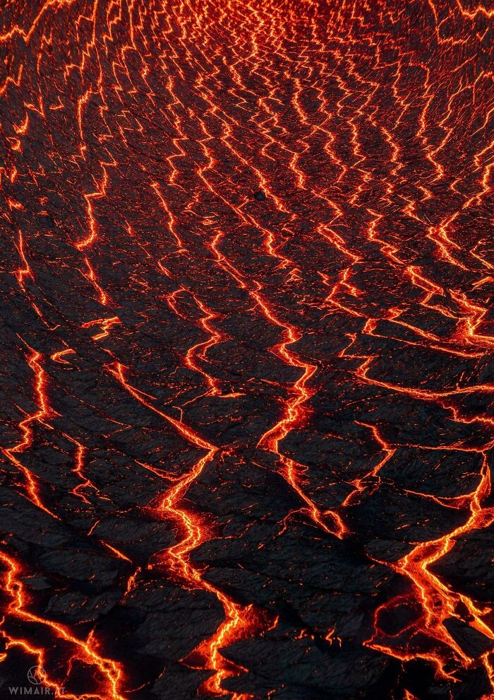 Molten lava flowing in intricate patterns, showcasing the incredible world photos theme with vibrant red and orange hues.