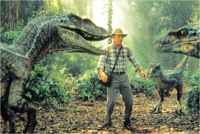 A man in a jungle surrounded by dinosaurs, illustrating a fascinating fan theory scene.