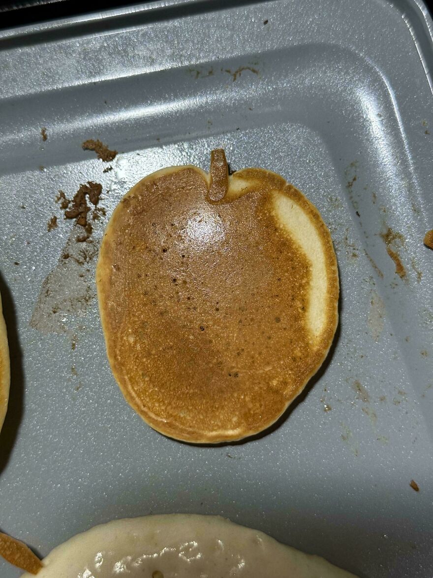 A pancake that looks like an apple on a baking tray.