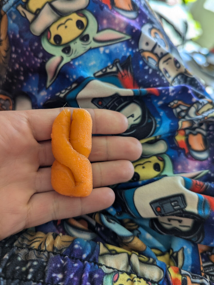 Curled carrot piece resembling a duck resting on a colorful Star Wars blanket.