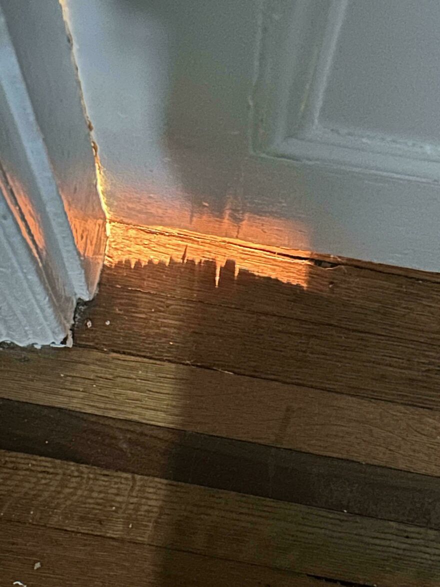 Image of sunlight under a door creating a cityscape illusion on wooden floor, illustrating things look like other things.