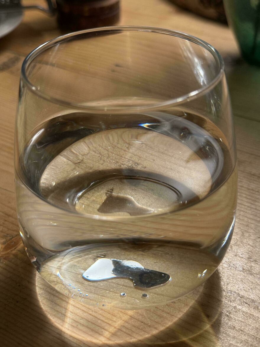 A rock in a glass of water resembling an island, showcasing how things look like other things.