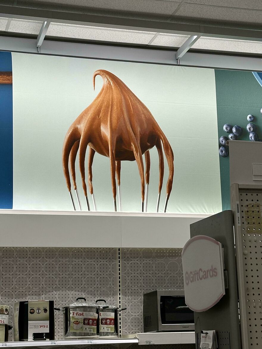 Poster of chocolate mix resembling an alien creature with tentacles above a store shelf.