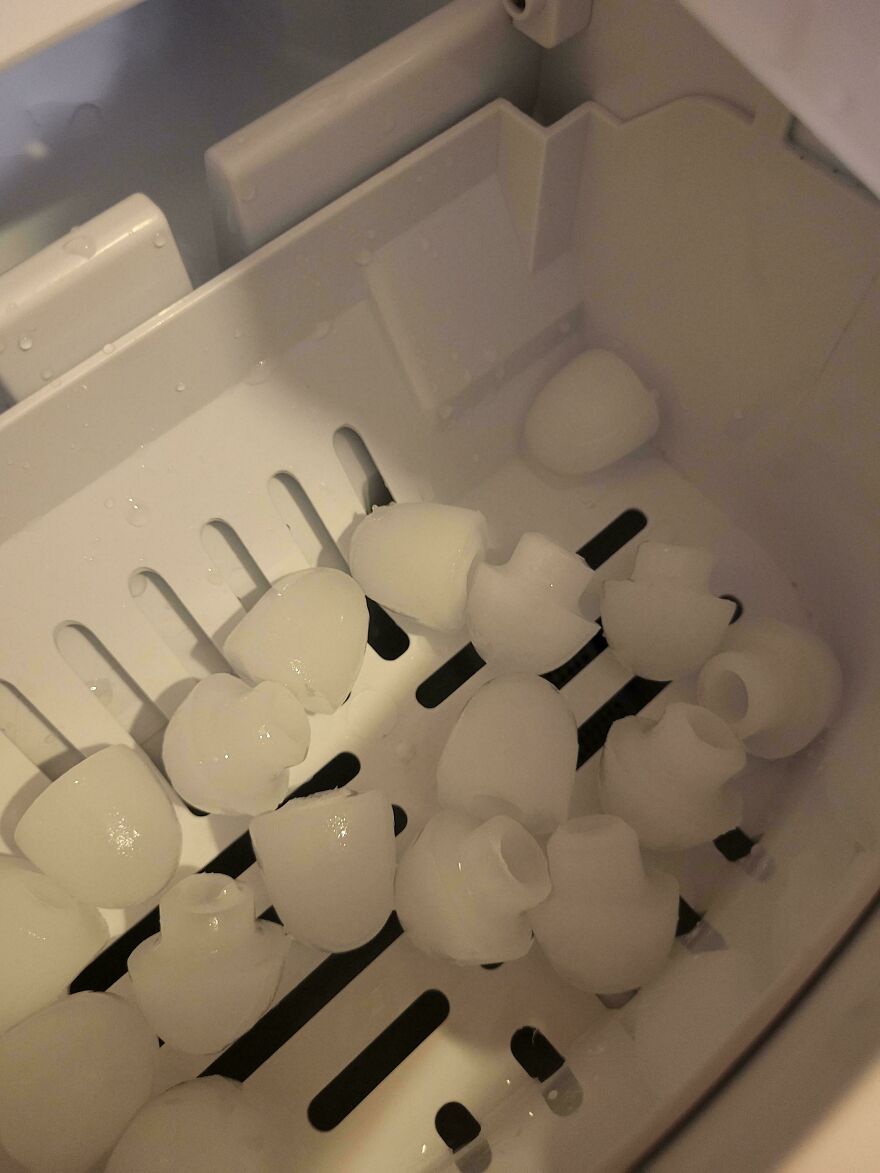 Ice cubes resembling molar teeth inside a freezer tray.