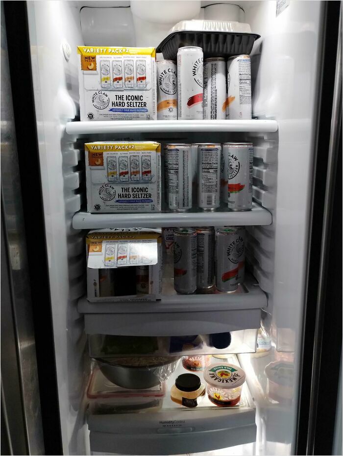 Fridge packed with hard seltzer and minimal food items, an amusing depiction of horrible-roommates behavior.