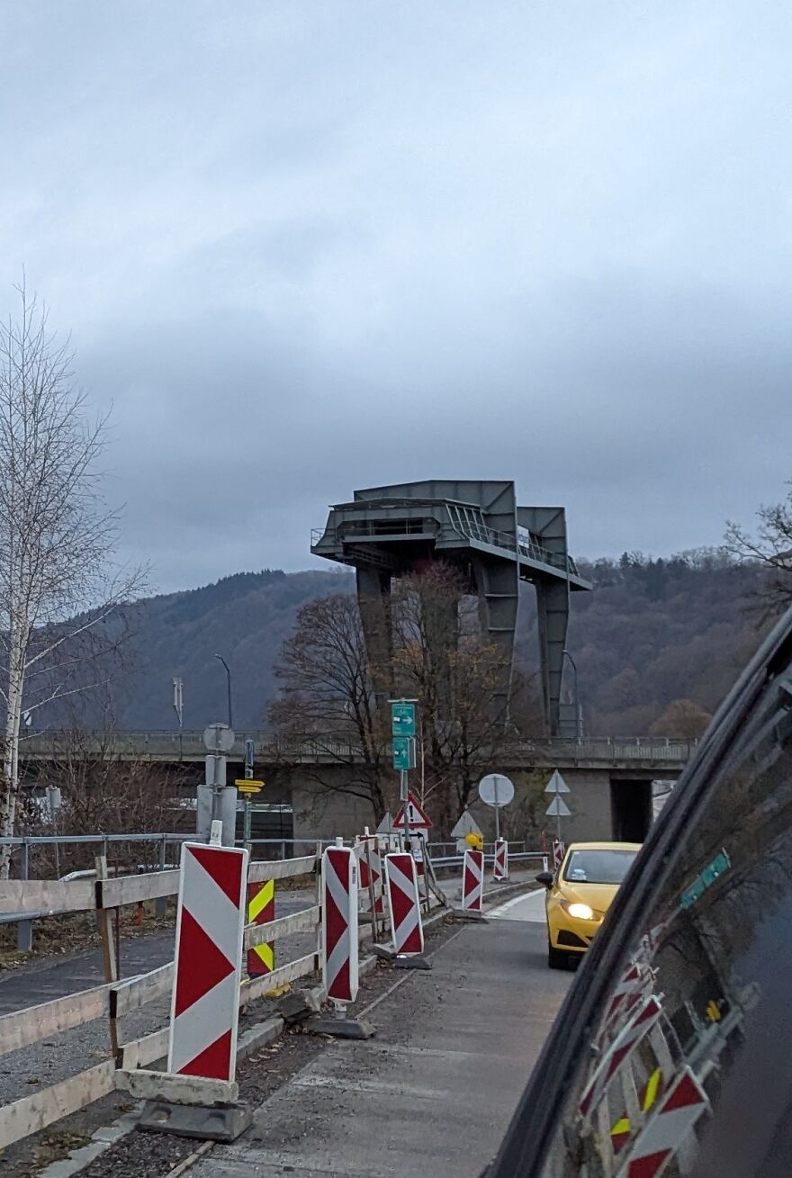 Structure resembling an elephant amidst a construction zone with a car driving by, highlighting things looking like other things.