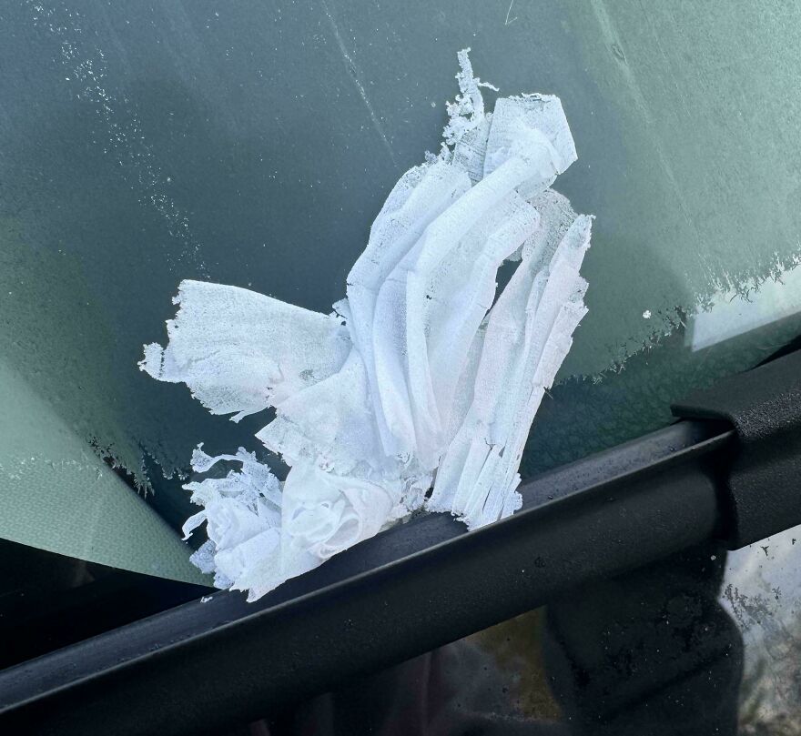 Frost on a windshield resembling crumpled paper under a wiper.