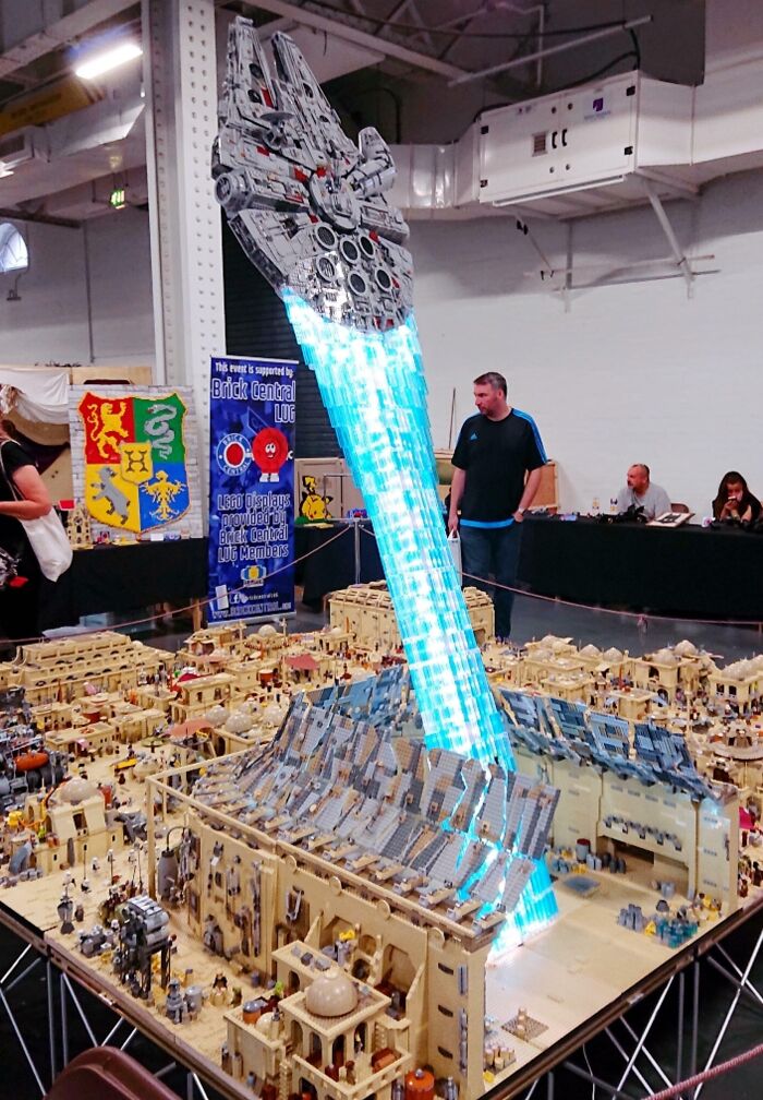 Cool LEGO build of a spaceship taking off from a detailed city diorama at a display event.