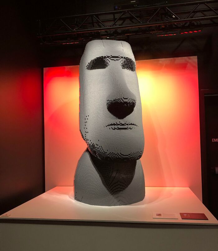 LEGO sculpture of a Moai statue against a glowing red and white backdrop. Cool-LEGO-Builds exhibition piece.