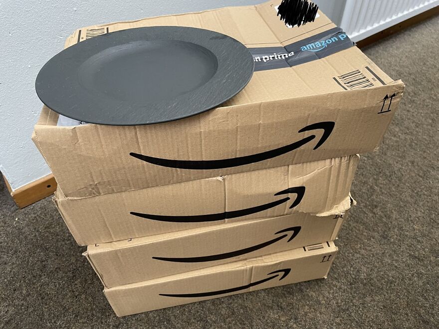 Stack of Amazon boxes illustrating wasteful packaging for a single plate.