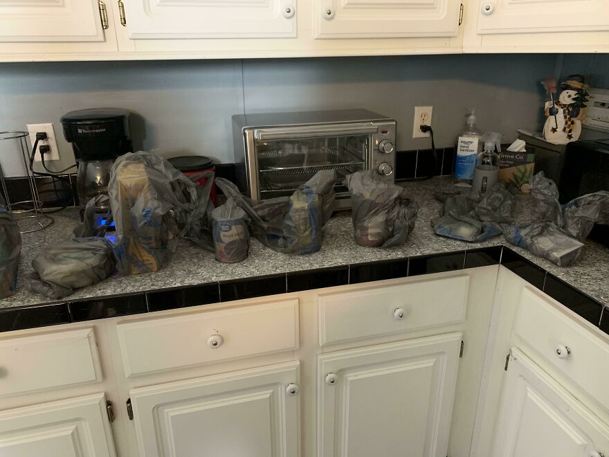 Plastic bags covering individual items on a kitchen counter, highlighting wasteful packaging.