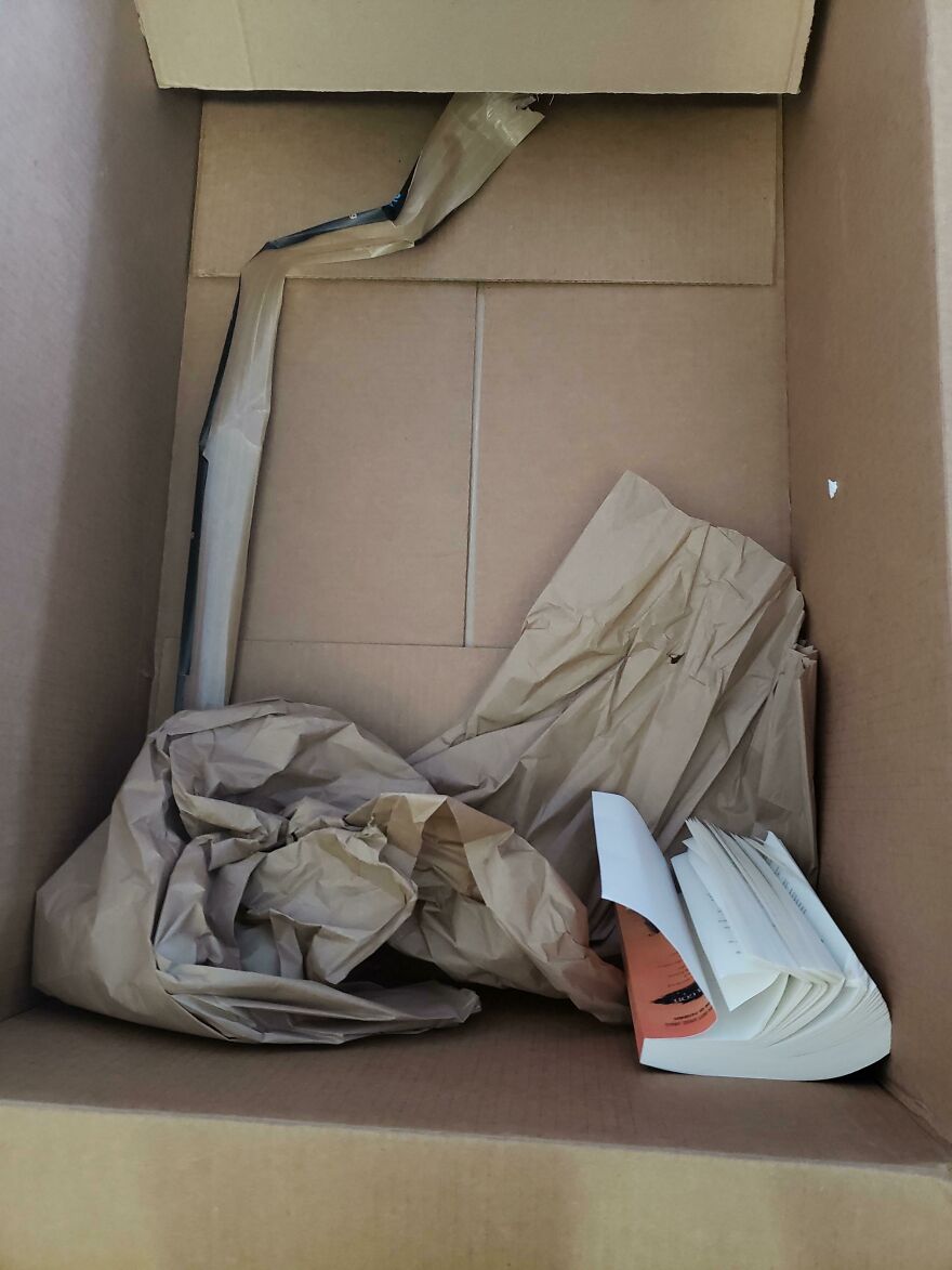 Excessive packaging with crumpled paper inside a large cardboard box for a single small book.