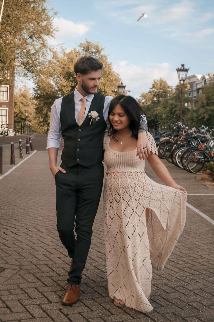 Couple walking on a street; woman wearing a crocheted dress.