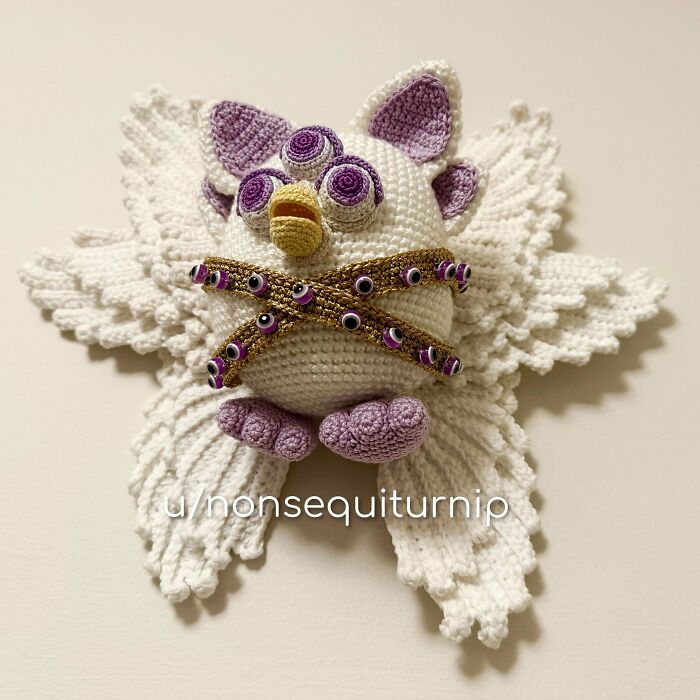 Crocheted owl with purple and white details, showcasing intricate handmade artistry.