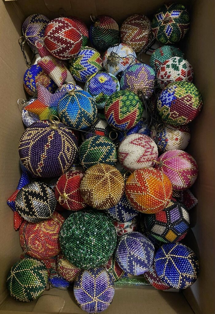 Colorful crocheted balls with intricate patterns packed in a box.