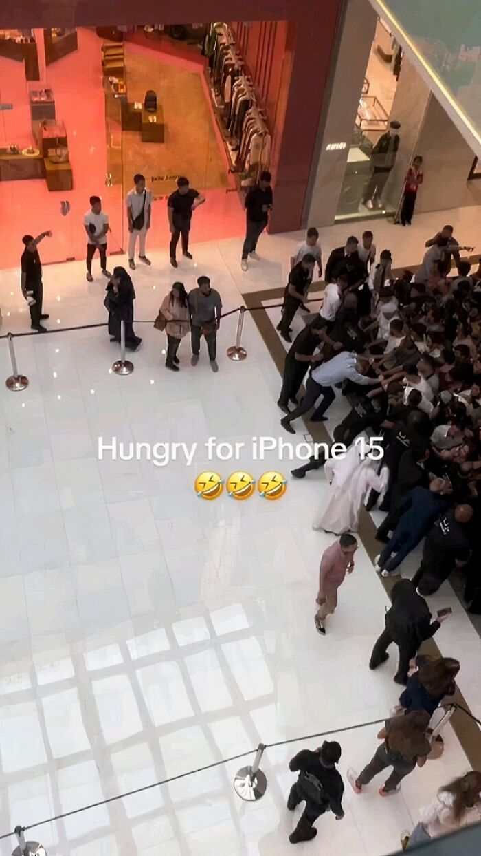 Crowd gathering in a mall for an iPhone release, capturing modern commerce and humans of capitalism in action.