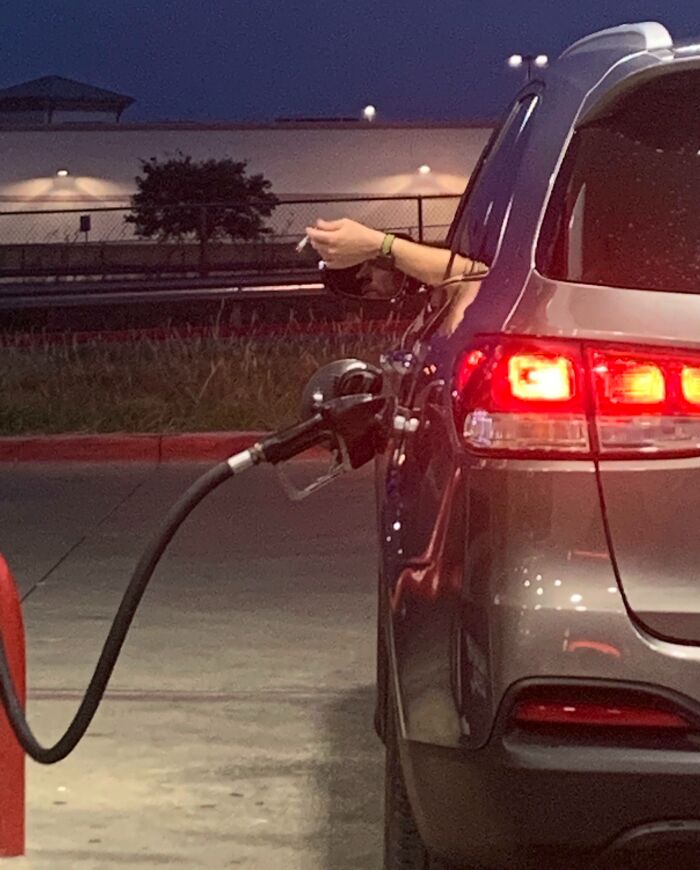 Car driving off with gas pump attached, illustrating a common mistake often seen in "Idiots-In-Cars" posts.