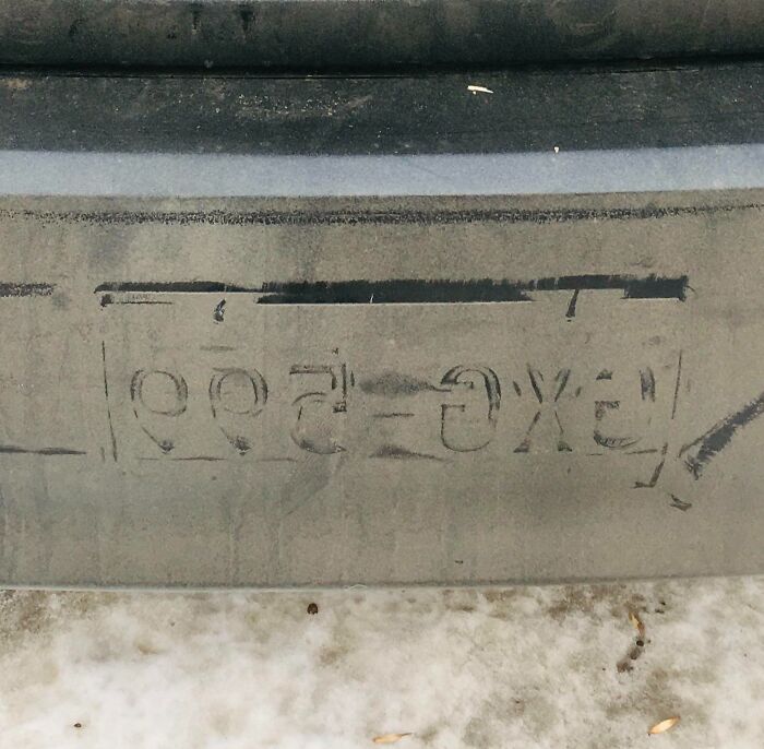 Dirty car bumper with "wash me" written in the mud, highlighting poor car maintenance.