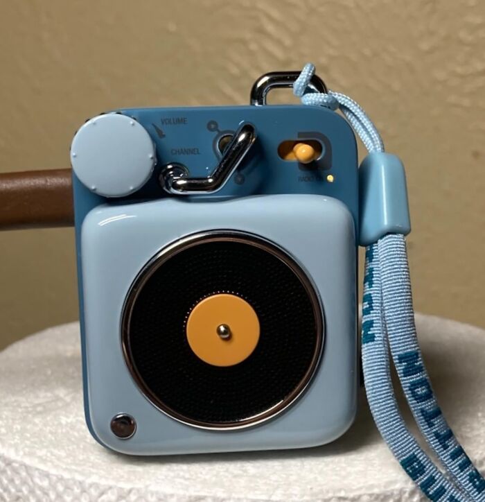 Blue novelty mini speaker with orange accents, featuring volume and channel knobs, adding fun to your daily routine.