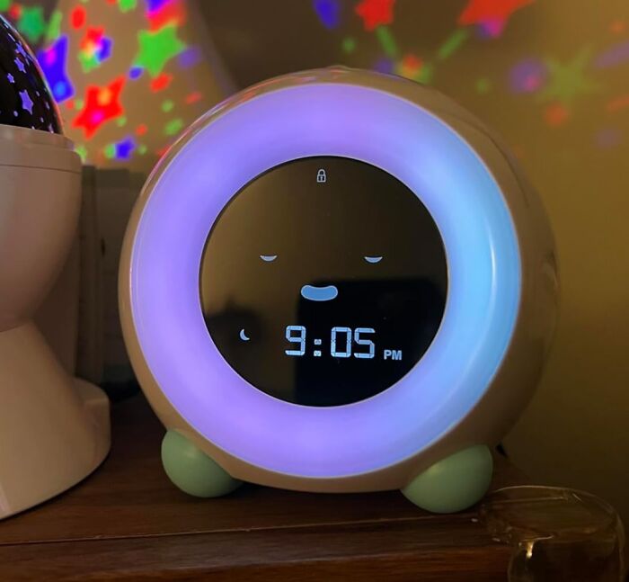 Novelty clock with glowing face displaying 9:05 PM, adding fun to your daily routine with colorful star projections.