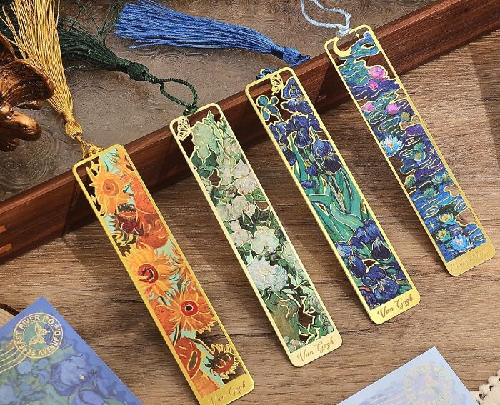 Four colorful Van Gogh-themed novelty bookmarks with tassels displayed on a wooden surface.