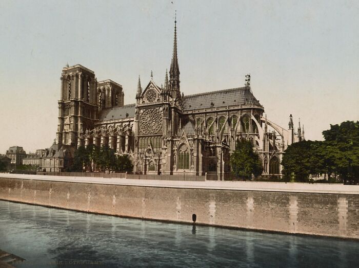 Historic Gothic church by the riverside, showcasing intricate architecture and towering spires.