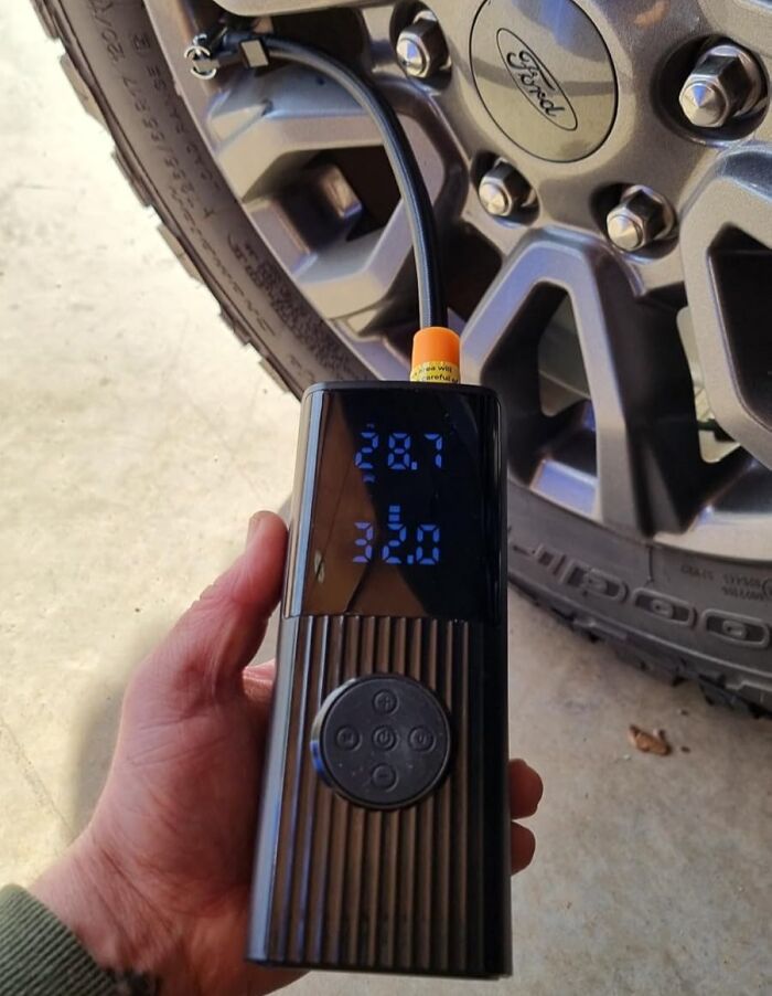 Digital tire inflator next to a Ford wheel, featured in Amazon winter deals discounts.