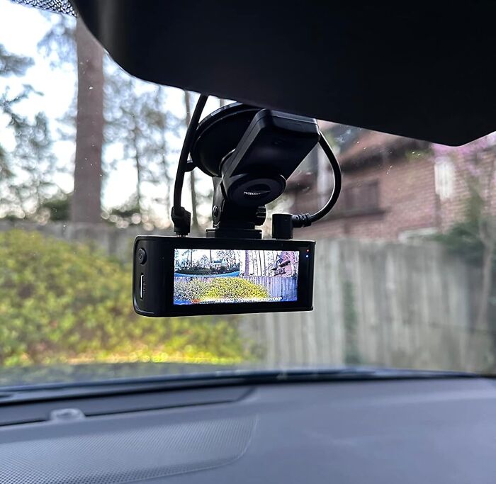 Dash cam on windshield displaying outdoor view, part of Amazon winter deals discounts.