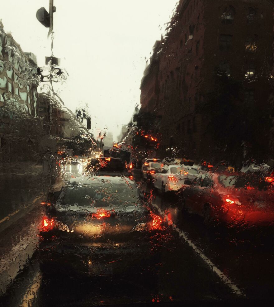 Traffic lights blurred through a rainy windshield, creating accidental art.