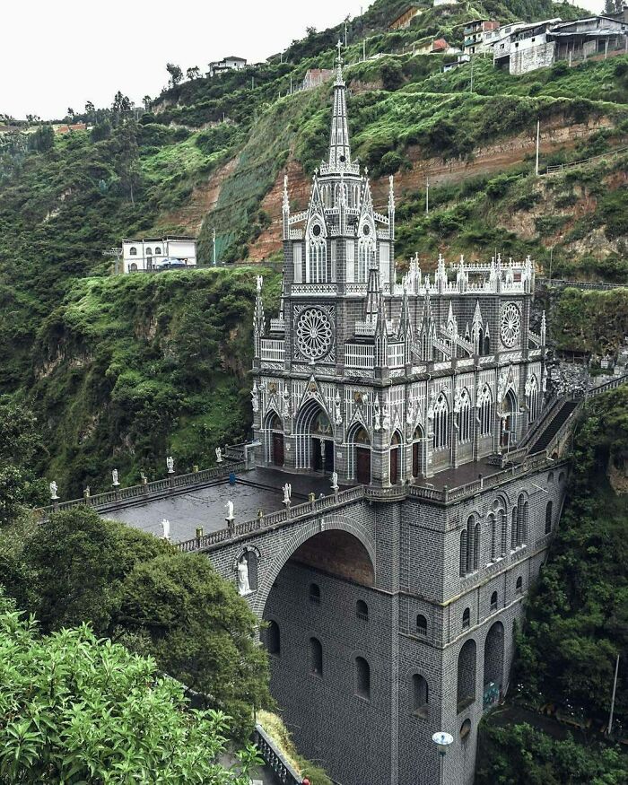 Gothic church nestled in lush green mountains showcases fascinating architecture.