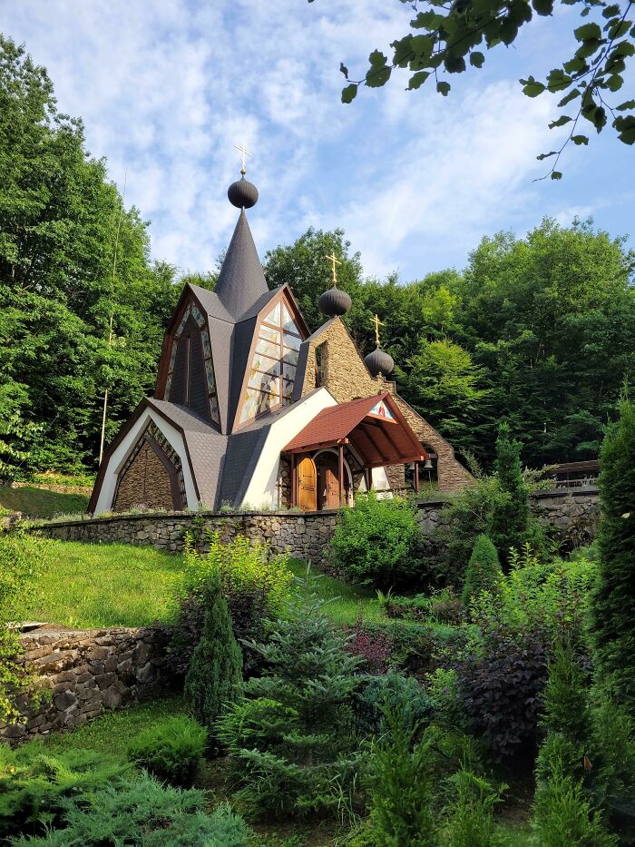 Unique church with pointed roofs and greenery, capturing the essence of fascinating church architecture.