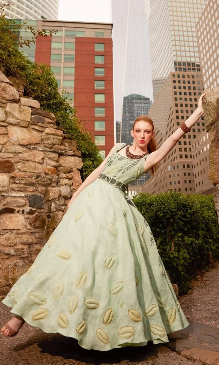 Fashion prodigy creation: model in a long green dress with cityscape backdrop.