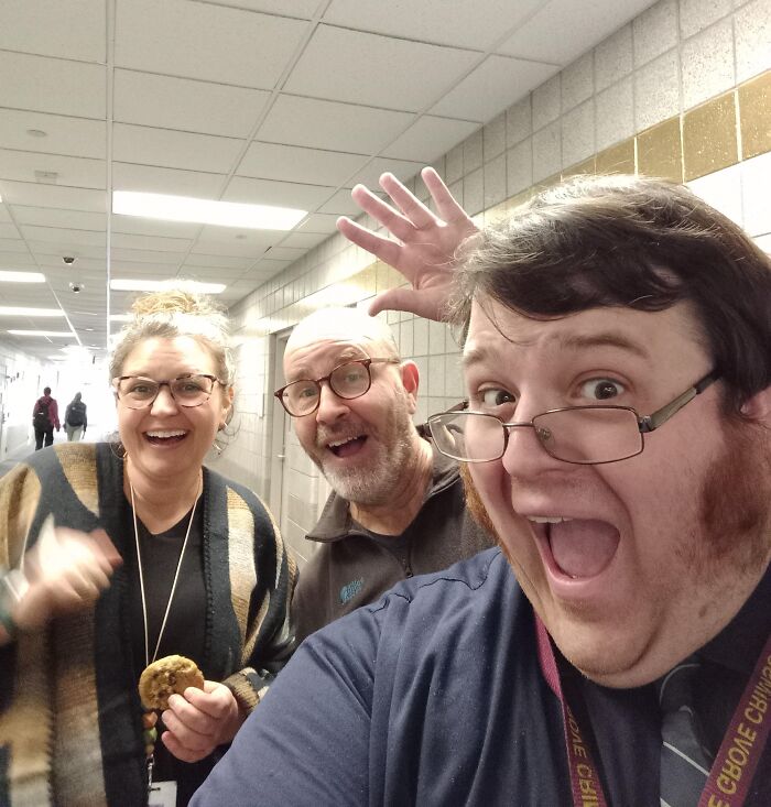 Three people posing excitedly in a hallway, capturing a funny-camera-roll moment.