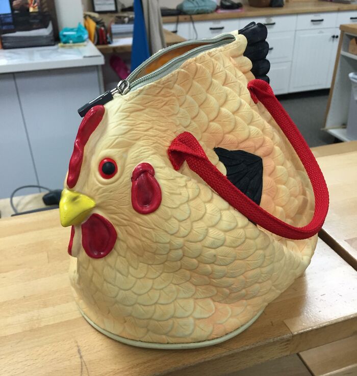 Chicken-shaped handbag on a table, showcasing quirky design. Funny-Camera-Roll-Finds.