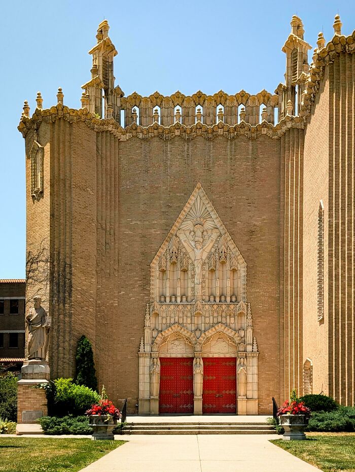 Ornate church facade with red doors and intricate architectural detailing.