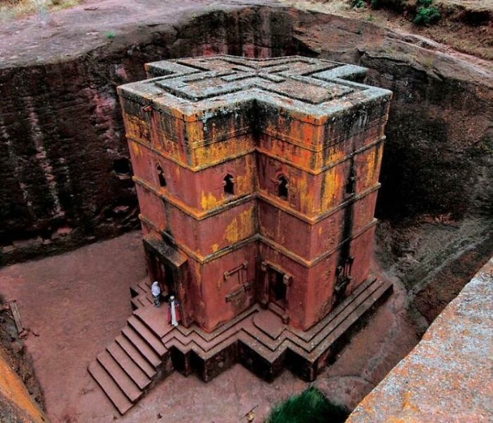 Ancient rock-hewn church carved into the ground, showcasing fascinating architecture and design.