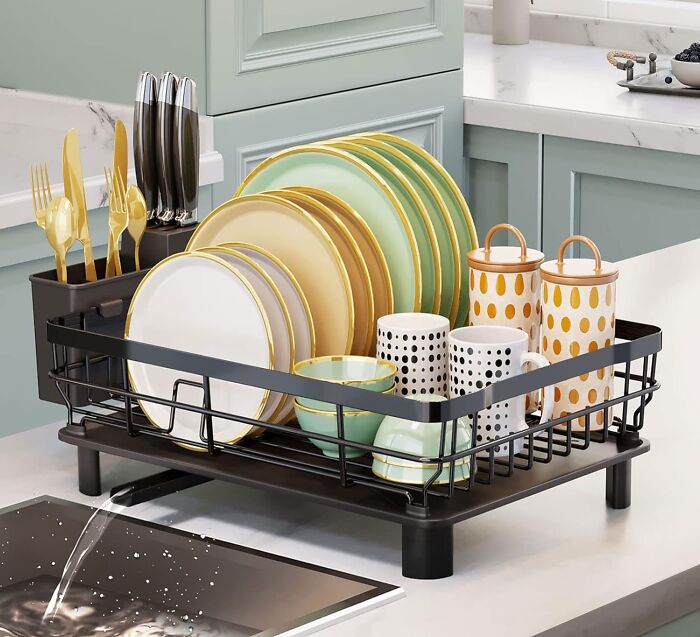 Dish rack with organized plates, cups, and utensils on a kitchen counter, epitomizing Less-Mess 2025 efficiency.