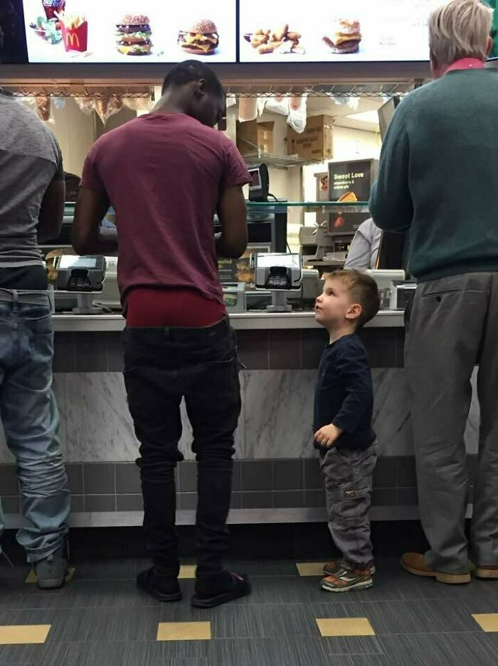 Young child humorously eyeing a customer at a fast-food counter, showcasing hilarious-kids moments.