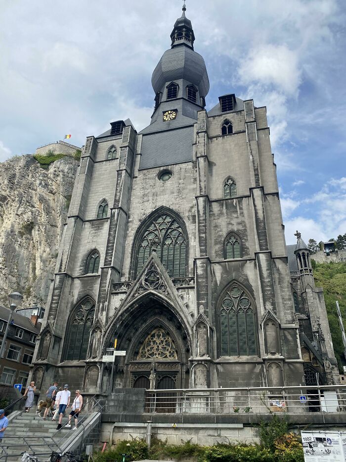 Gothic church facade with intricate architecture against a cloudy sky, highlighting fascinating church details.