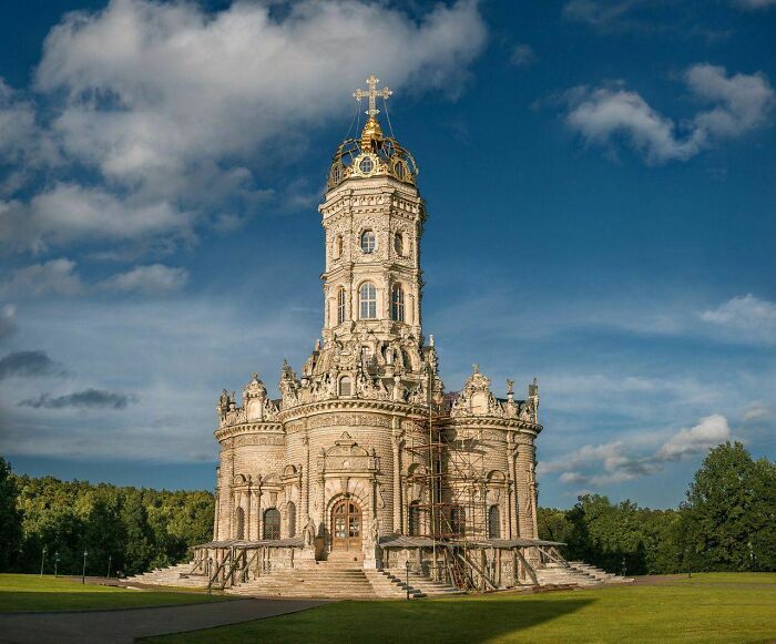 Ornate baroque church with elaborate architecture under a blue sky, showcasing fascinating church details.