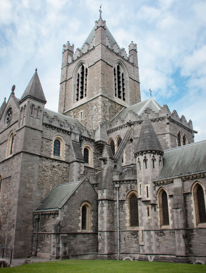 Gothic church architecture with stone towers and arches under a blue sky, showcasing fascinating church details.