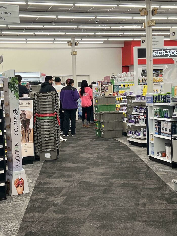 People waiting in line at a local pharmacy, showcasing a typical bustling atmosphere.