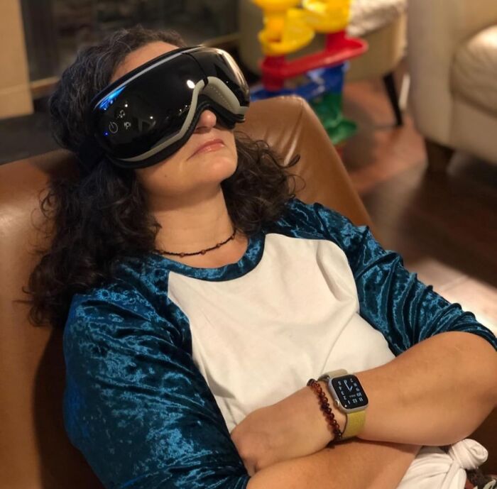 Person relaxing with VR goggles and smartwatch, embodying cozy products for doing nothing indoors.