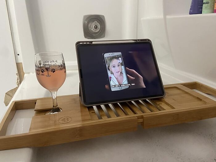 Bathtub tray with tablet and wine glass; a cozy product for relaxing indoors.