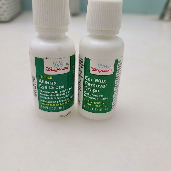 Allergy eye drops and ear wax removal drops from local pharmacies on a countertop.