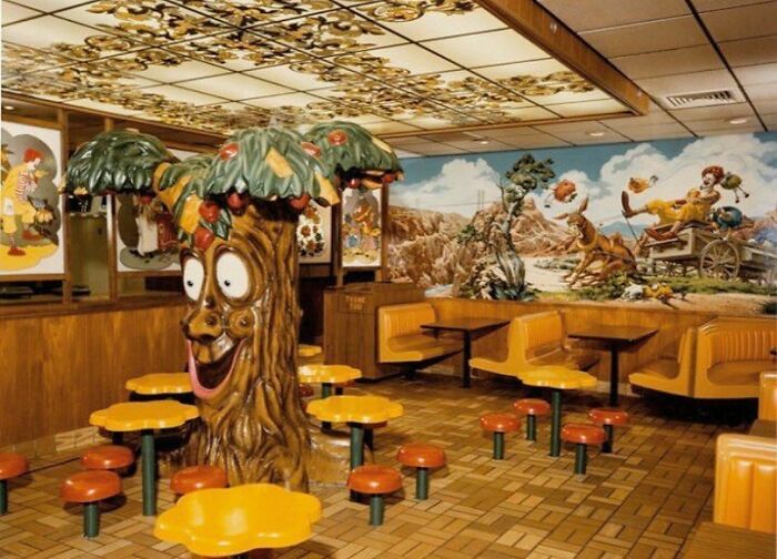 80s nostalgia picture of a whimsical fast-food restaurant interior with playful decor and booths.